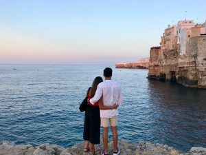 Couple overlooking the Adriatic Sea at sunset in Polignano a Mare, Puglia, Italy